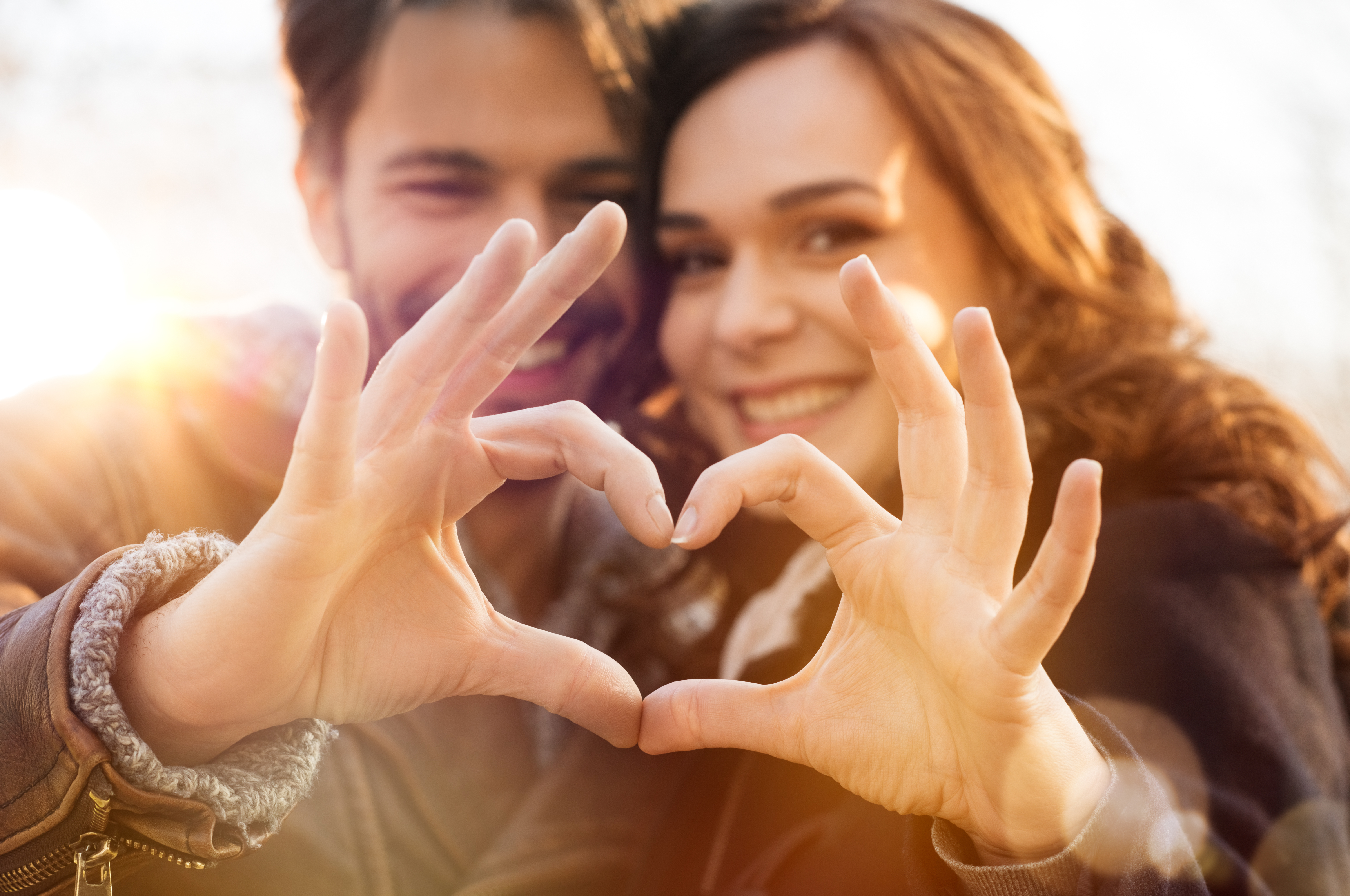 man and woman showing the ok sign with their hands